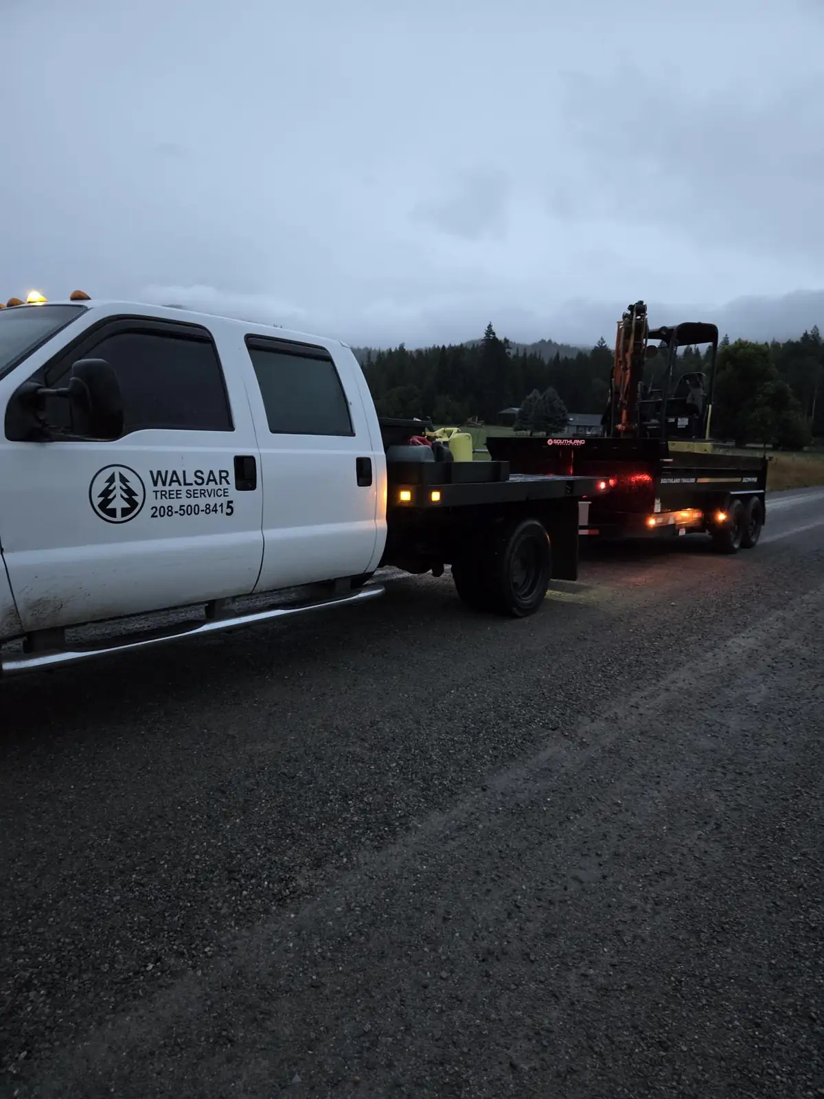 Walsar pickup towing an equipment trailer at dusk